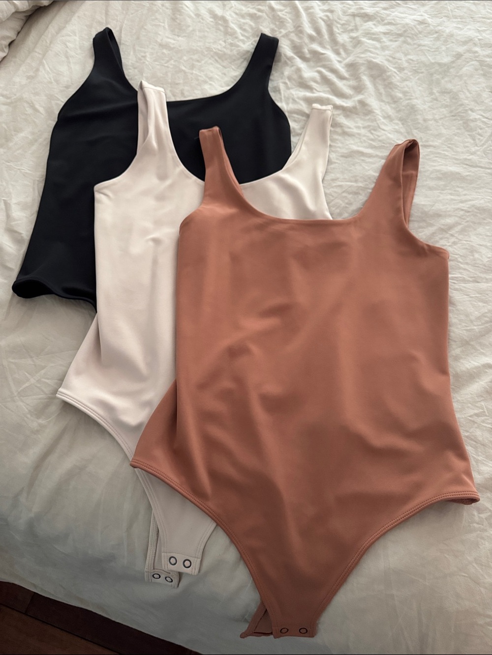 Women’s Express “body contouring” bodysuits in Black, Cream, and Rust